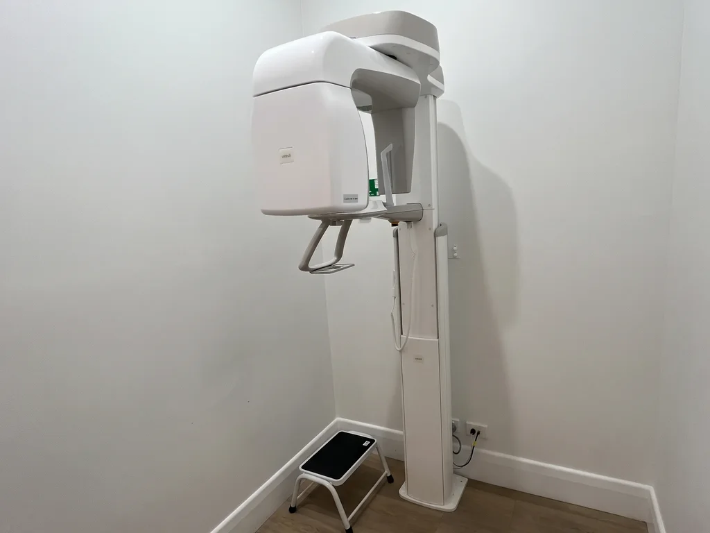 Orthopantomography (OPG) machine: a Vatech panoramic dental X-ray unit on its column, with a step stool beside it