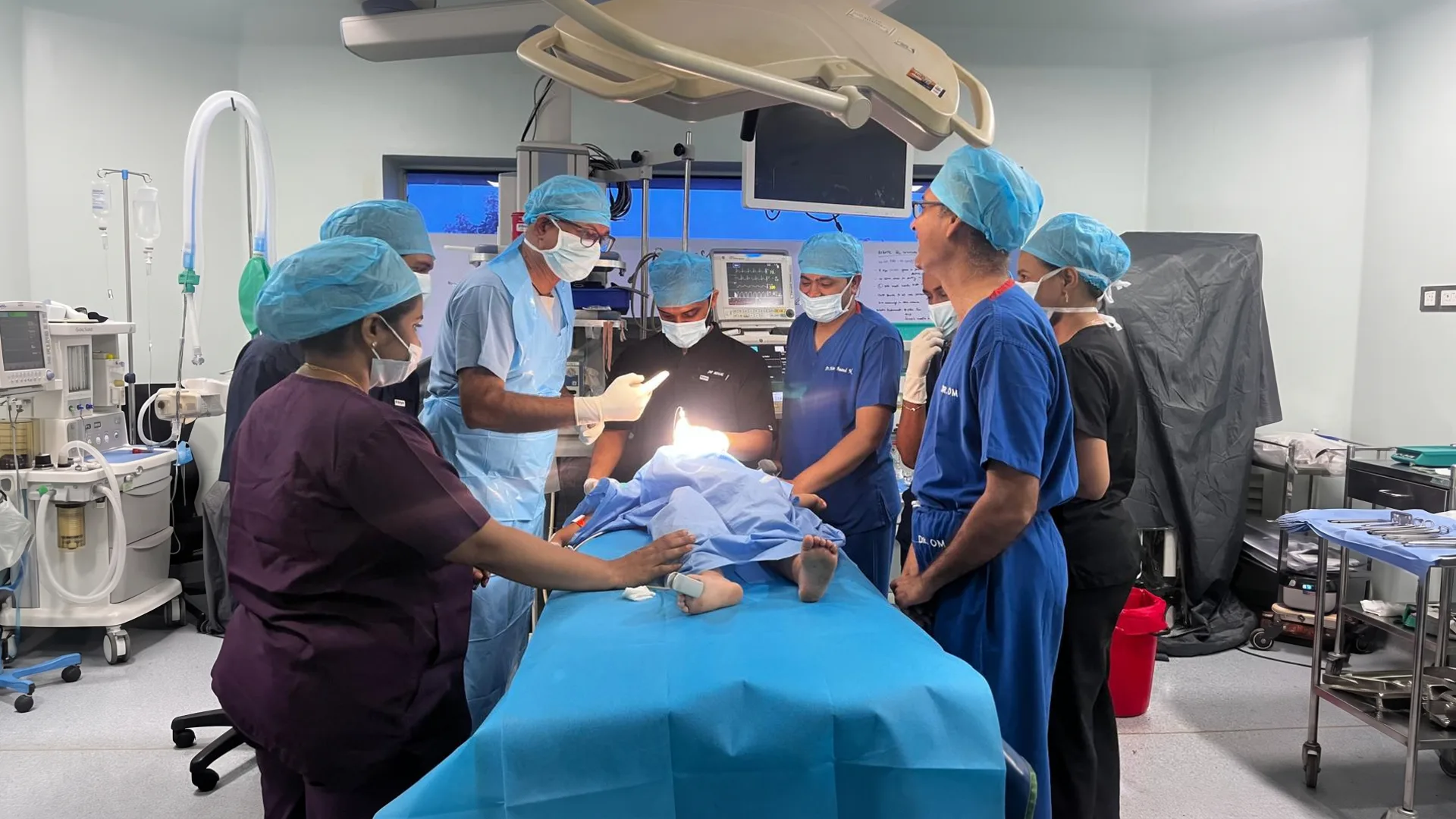 The team gathered around the table in the operating theatre